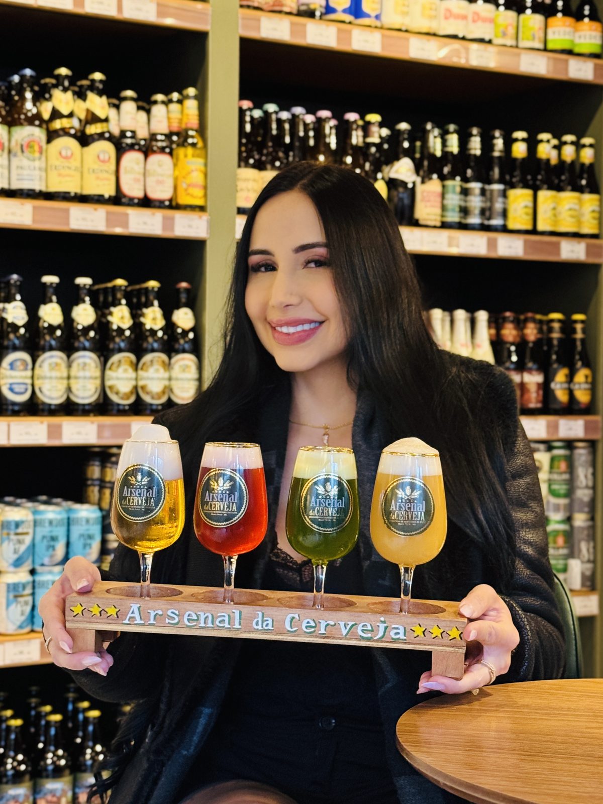 Cliente sorrindo segurando a régua de degustação com quatro taças coloridas