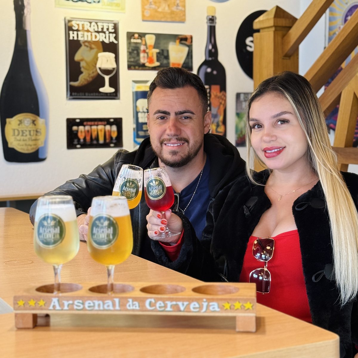 Casal brindando com as taças da régua de degustação do Arsenal da Cerveja